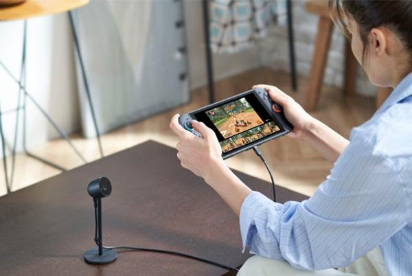a woman playing a video game on a nintendo switch 2 while sitting on a sofa