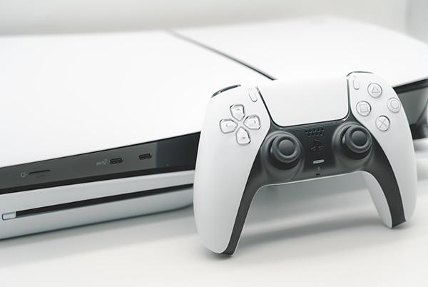 a playstation dualsense controller on a white table in front of a ps5