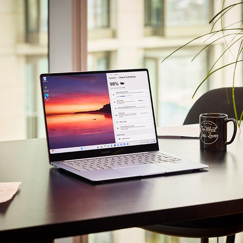a laptop computer sitting on a desk showing the battery status on the screen
