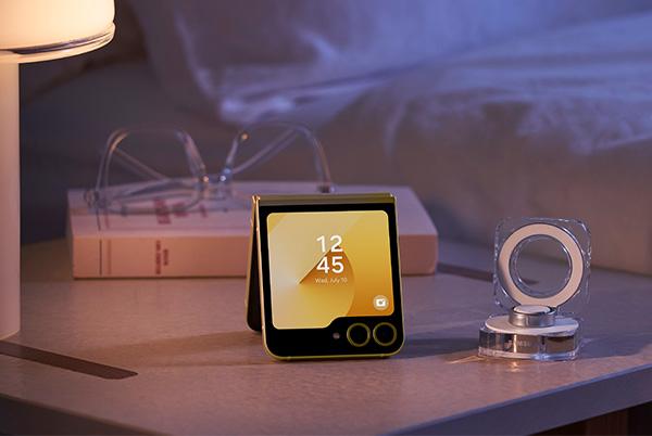 a bedside table with a samsung ring in case next to a flip6 phone