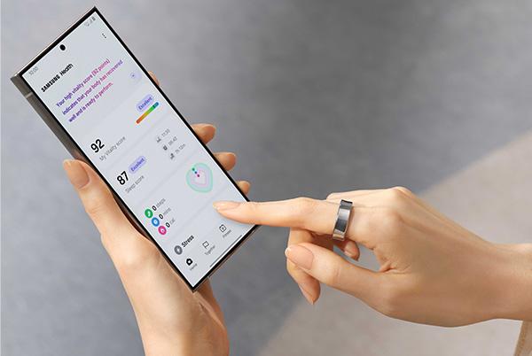 a woman holding a smart phone with a finger on the screen using samsung health app
