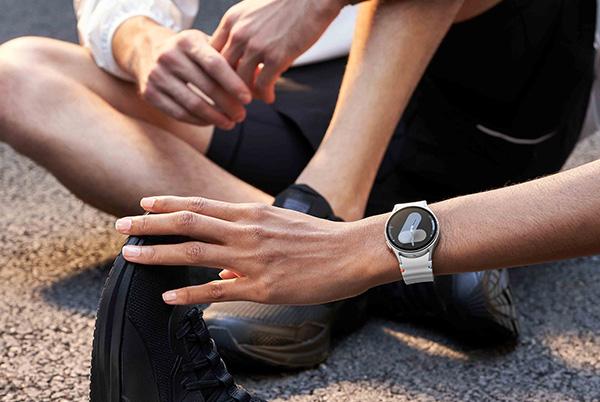 a man sitting on the ground wearing a samsung watch 7