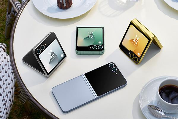 a table with four samsung galaxy z flip6 phones and a mug of coffee