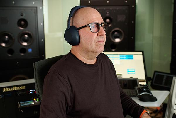 a man sitting in a chair with headphones on listening to music