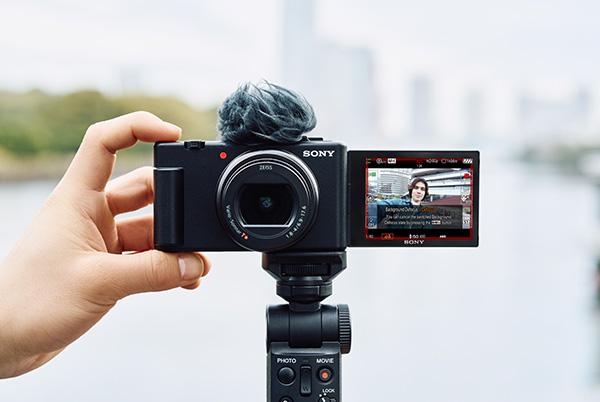 a person holding a camera with a small screen on it