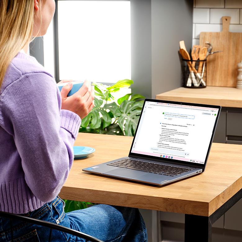 person using google gemini ai feature on lenovo ideapad flex 5 laptop while sat at a desk