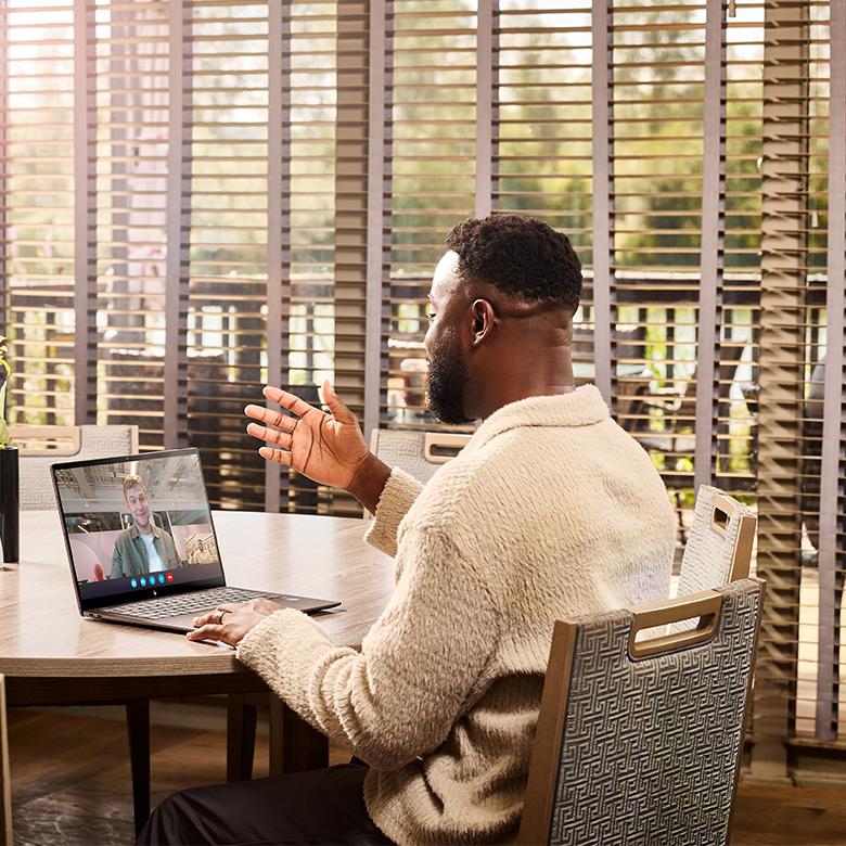 a man sitting at a table with a laptop on it