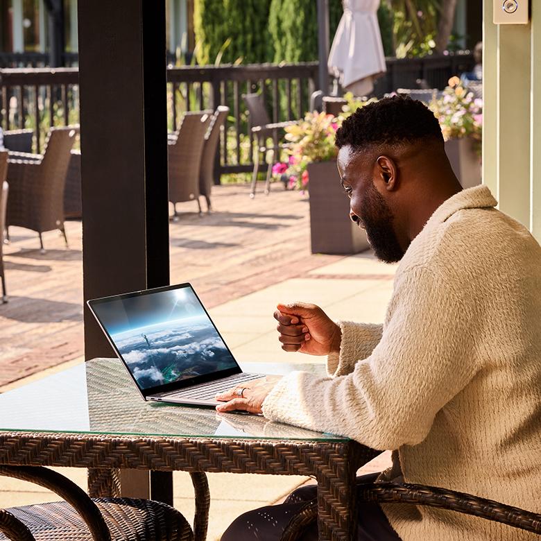 a man sitting at a table with a laptop on it