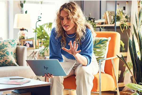 a woman sitting on a chair with a laptop in front of her