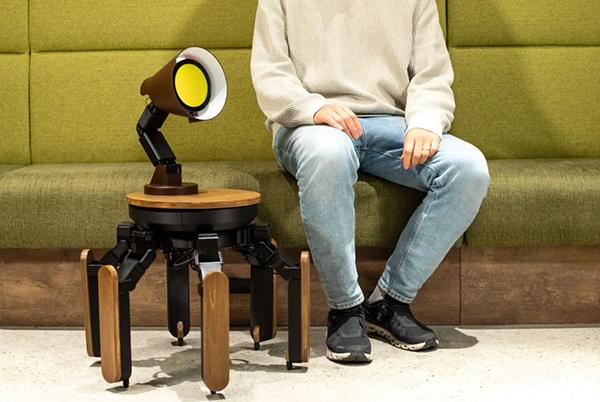 a man sitting on a green bench with a lamp on a table