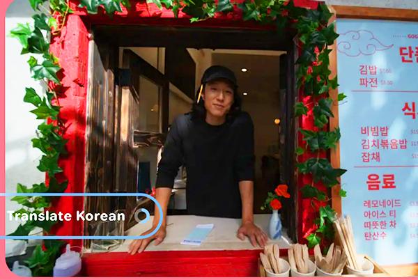 a man in a restaurant window with a sign that says "translate"