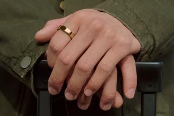 a person's hands are resting on a black suitcase with a gold ring