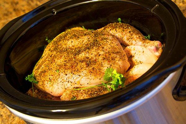 a slow cooker with a chicken in it on a counter