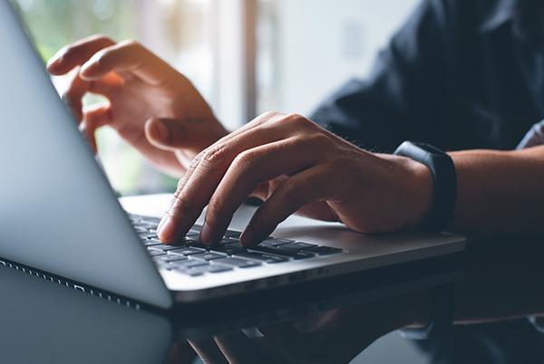 a person typing on a laptop computer 