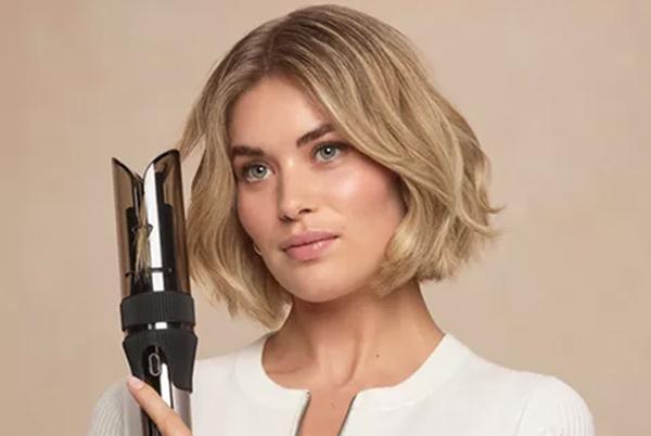 a woman holding a hair dryer in her hand and smiling