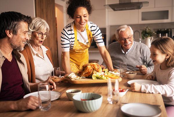 a family sitting around a table with an easter roast dinner