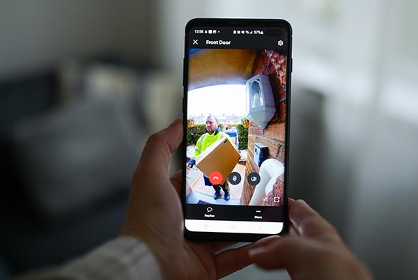 a person holding a mobile phone with a video of a delivery person