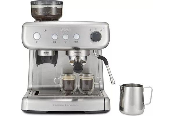 a silver coffee maker with two cups and a milk frother