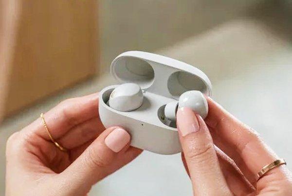 a person holding a pair of earbuds in their hands
