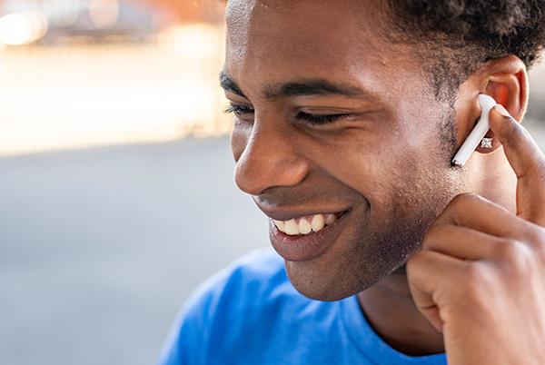 a man smiling while holding a cell phone to his ear