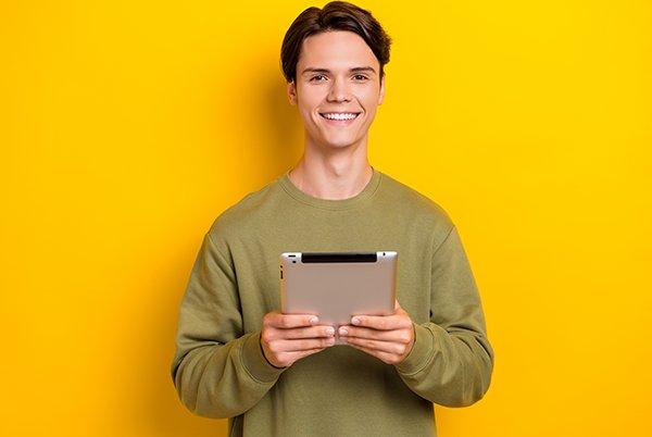 a man in a green sweater holding a tablet computer