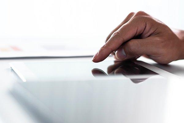 a person's hand on a tablet computer screen with a finger
