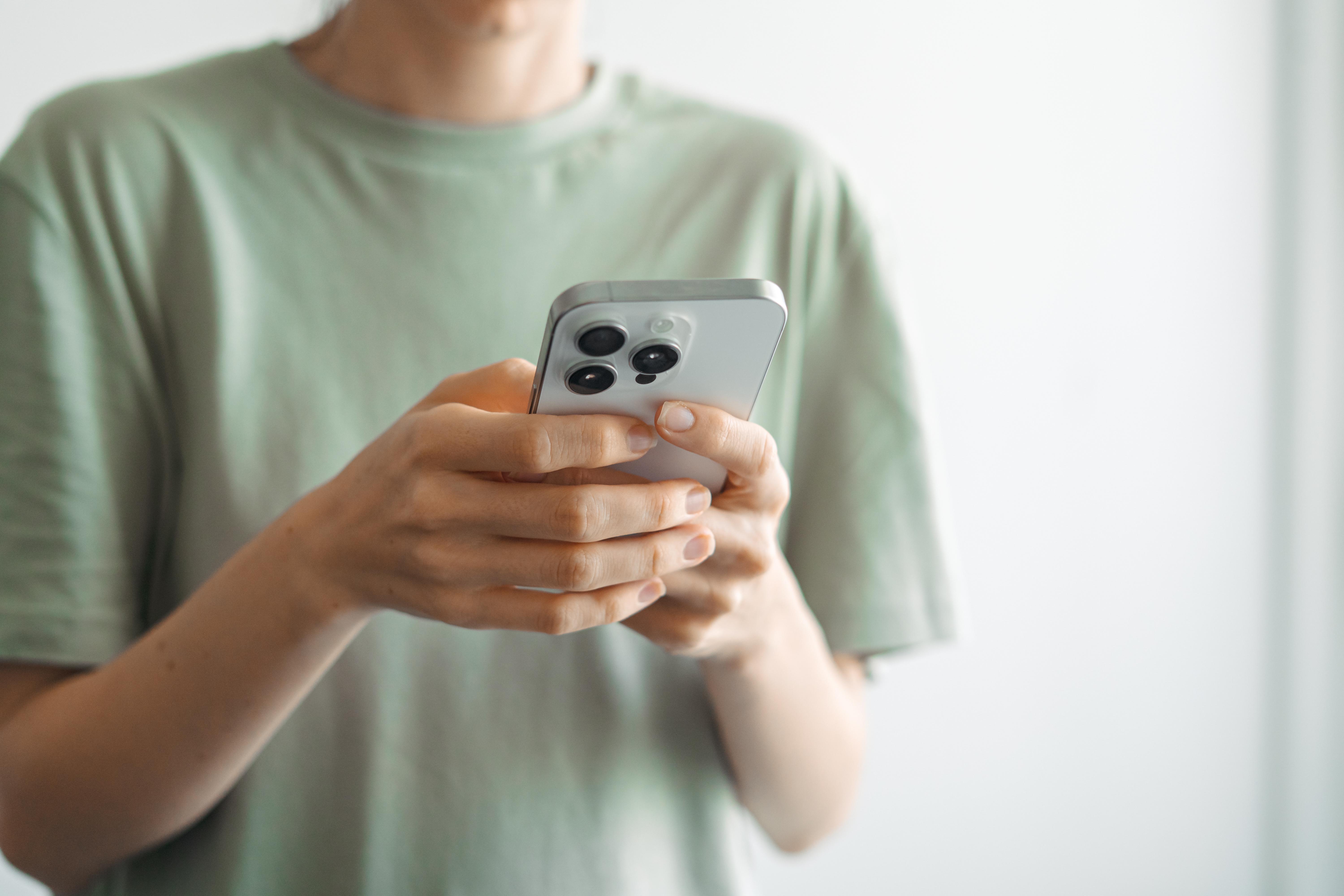 a person holding a mobile phone in their hand