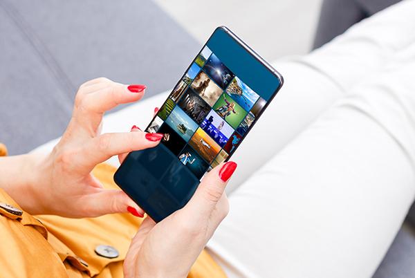 a woman holding an iPhone with a picture of her on it