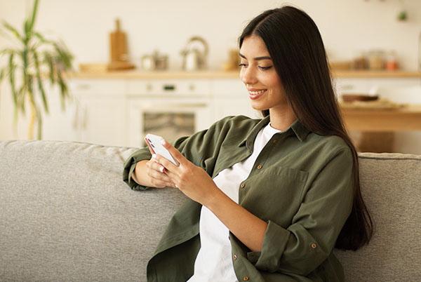 a woman sitting on a couch using her phone