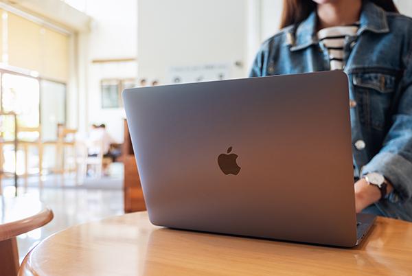 a woman sitting at a table with a laptop on it