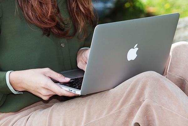 a woman sitting at a table with a laptop on it