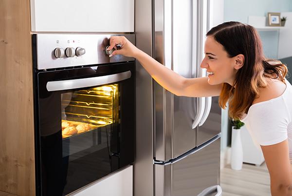 a woman opening a built-in oven door
