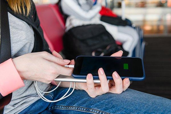a woman sitting in a chair with a cell phone and a charger
