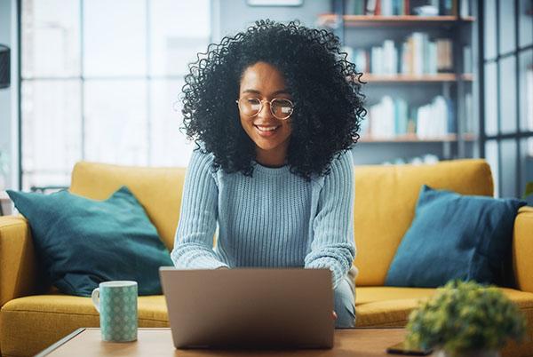 a woman sitting on a couch with a laptop