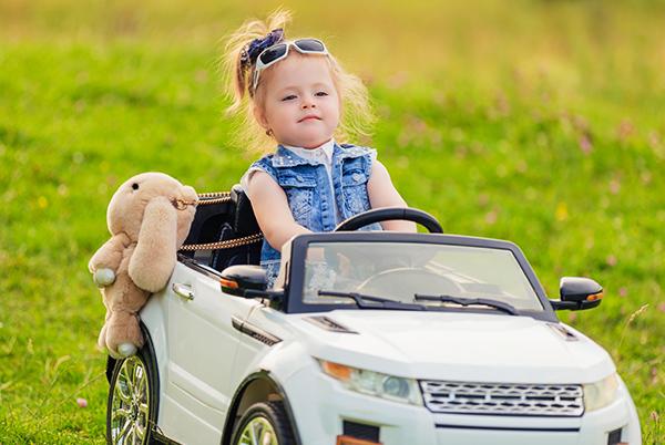 a little girl in a white car with a stuffed animal