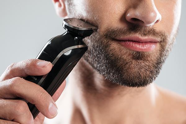 a man shaving his face with an electric shaver