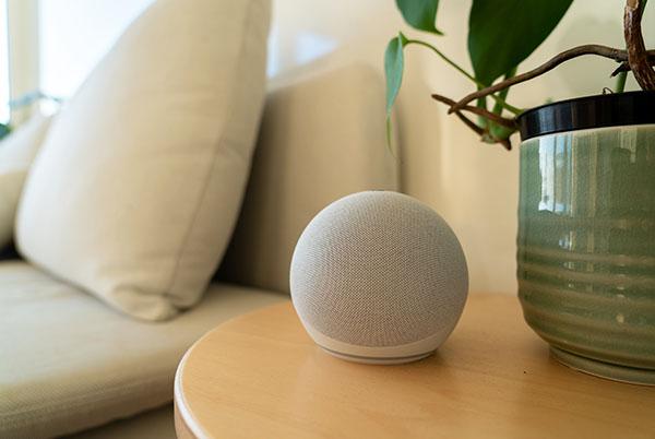 an amazon echo smart speaker sitting on top of a wooden table