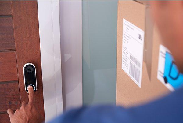 a man opening a door with a smart doorbell on the door