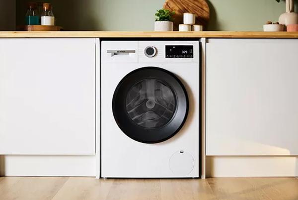 a white washer sitting in a kitchen with wooden floors