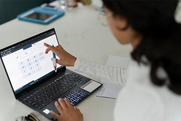 a woman using a 2 in 1 laptop computer touchscreen