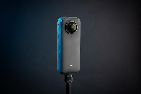 a 360 camera with a blue and gray color on a black background