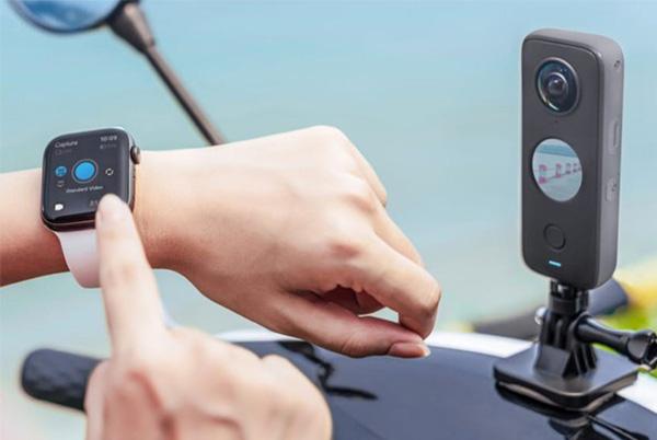 a person is connecting and using a smart watch with a 360 camera on a motorcycle