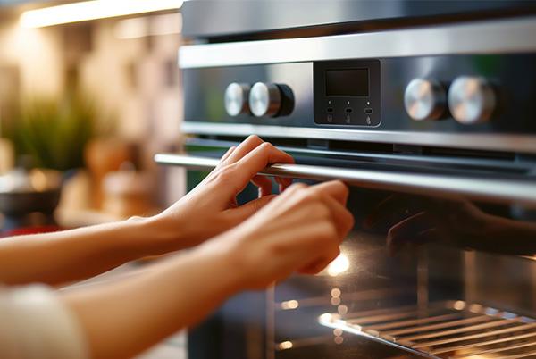 a woman is putting food in the oven and closing the door