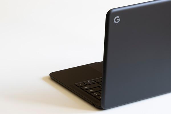 a black chromebook laptop sitting on a white surface with a keyboard