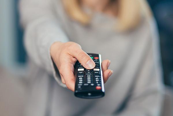 a woman holding a remote control in her hand