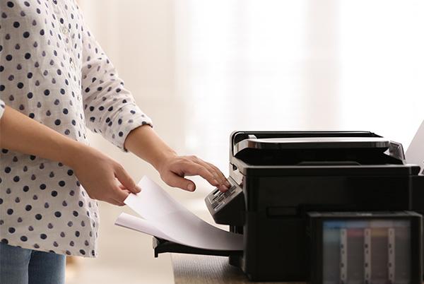 a woman in a polka dot shirt is using a printer