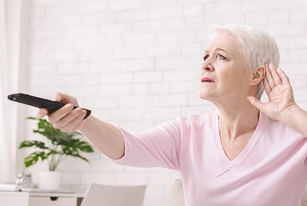 a woman sitting on a couch holding a remote control