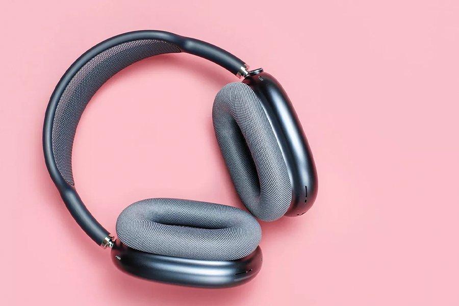 A set of over-ear headphones on a pink background