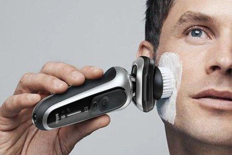 a man cleaning his face with a facial cleansing brush