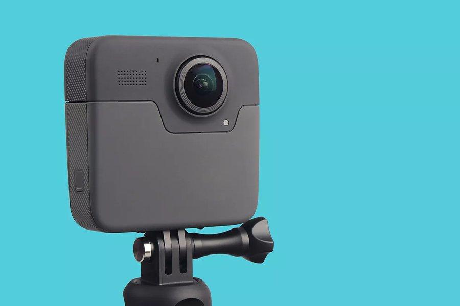 A 360 camera on a tripod in front of a bright blue background